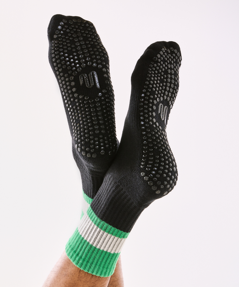 High-quality men's crew non slip grip socks in classic black and vibrant green